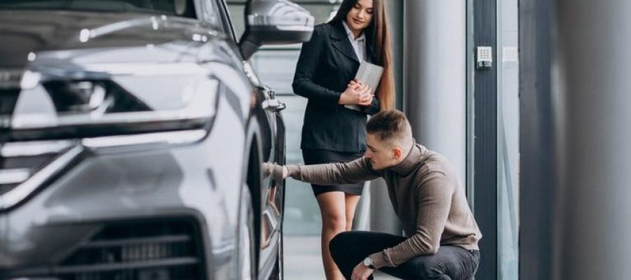 Hombre revisando un coche antes de contratar el transporte del vehículo